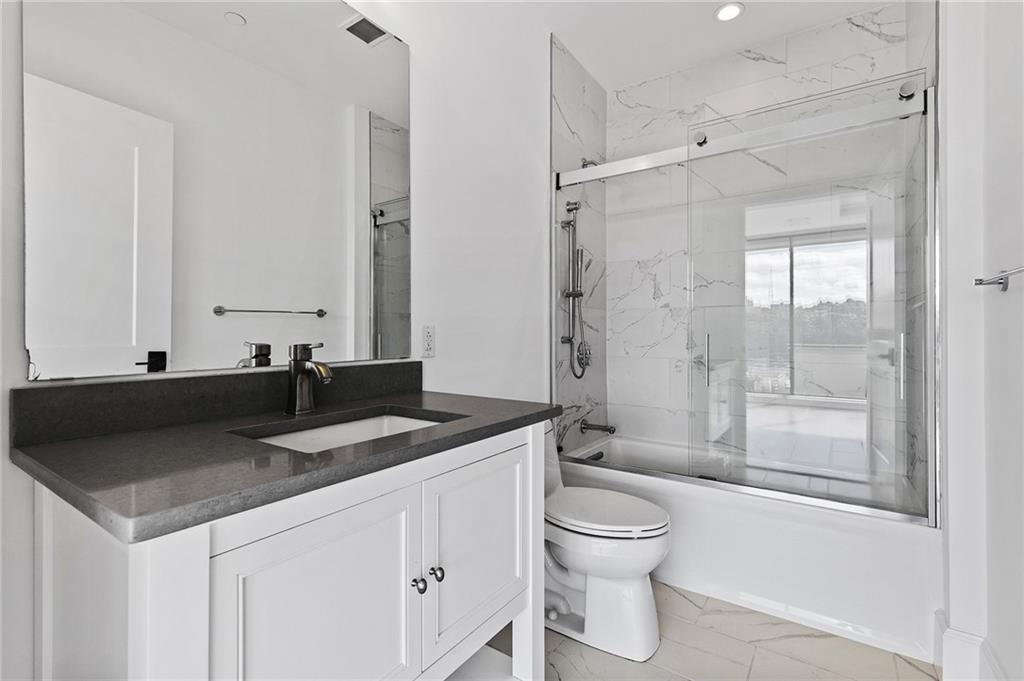 350 Oliver Avenue, Unit 1605 Pittsburgh, PA 15222 - Photo 16 of 40 a bathroom with a granite countertop sink toilet and shower