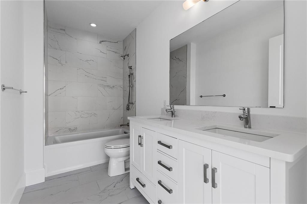 350 Oliver Avenue, Unit 1605 Pittsburgh, PA 15222 - Photo 22 of 40 a bathroom with a granite countertop sink toilet mirror and bathtub
