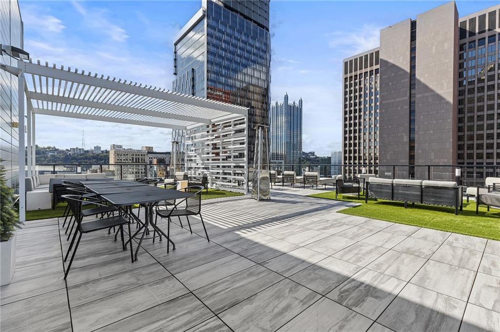 350 Oliver Avenue, Unit 1605 Pittsburgh, PA 15222 - Photo 29 of 40 a view of a patio with a table and chairs and wooden fence