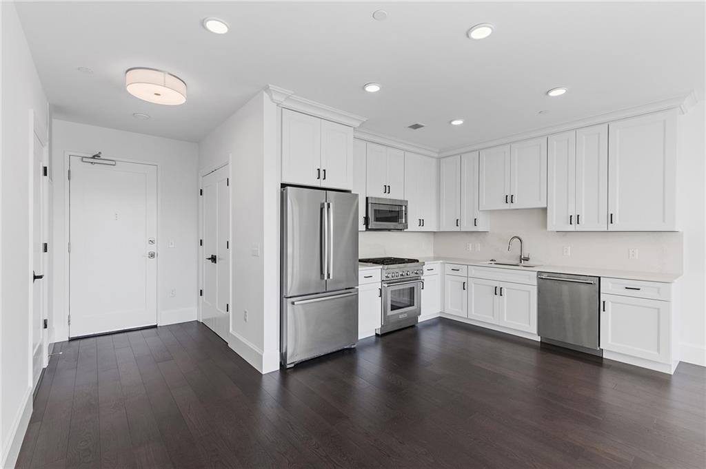350 Oliver Avenue, Unit 1605 Pittsburgh, PA 15222 - Photo 3 of 40 a kitchen with stainless steel appliances white cabinets and wooden floors