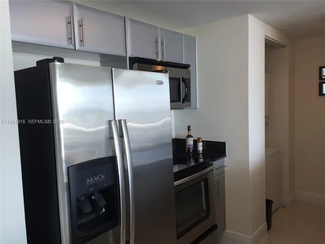 a metallic refrigerator freezer sitting in a kitchen