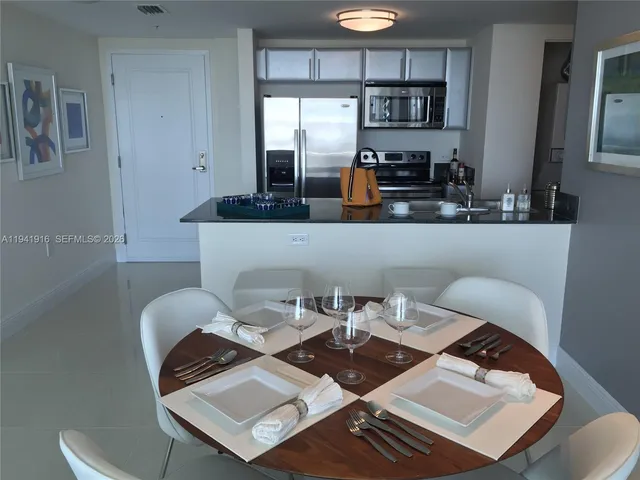 a view of a workspace with a table and chairs in kitchen