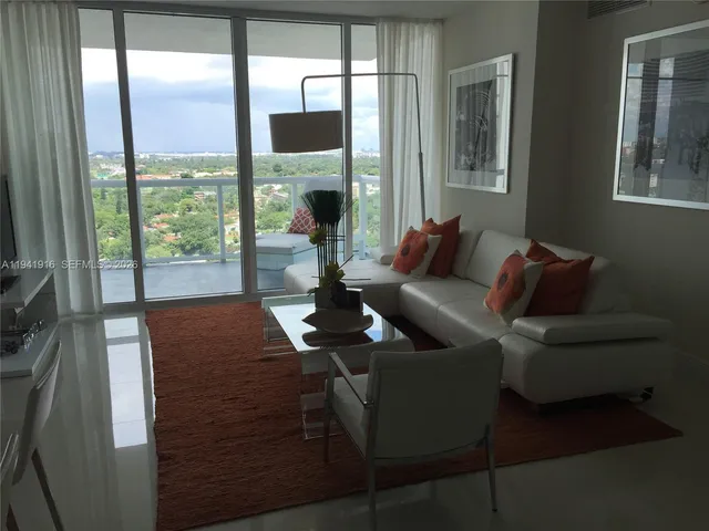 a living room with furniture and a floor to ceiling window