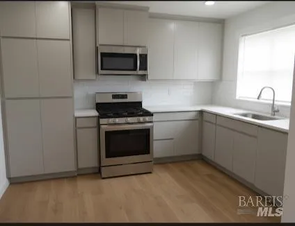 a kitchen with sink a microwave and cabinets