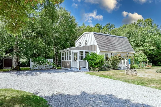 a view of a house with a yard and large trees