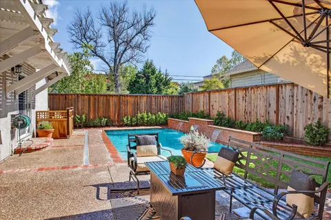 a view of a backyard with table and chairs under an umbrella