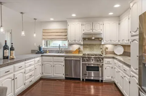 a kitchen with stainless steel appliances granite countertop a stove and a sink