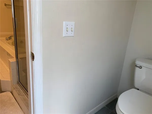 a white toilet sitting next to a shower