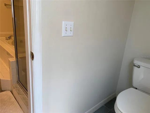 a white toilet sitting next to a shower