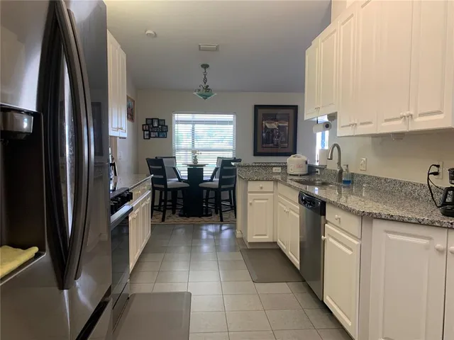 a kitchen with stainless steel appliances granite countertop a sink counter space cabinets and a large window