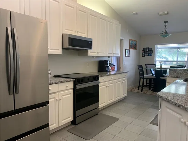 a kitchen with stainless steel appliances a stove microwave and refrigerator