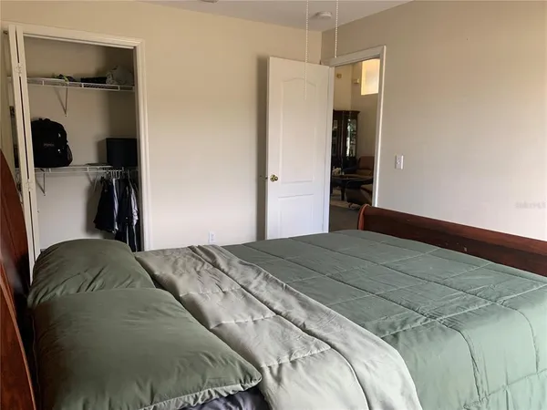 a bedroom with a bed and a refrigerator
