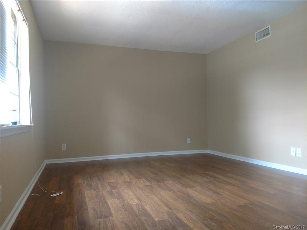 5803 Hunting Ridge Lane, Unit B Charlotte, NC 28212 - Photo 5 of 15 a view of an empty room with wooden floor and a window