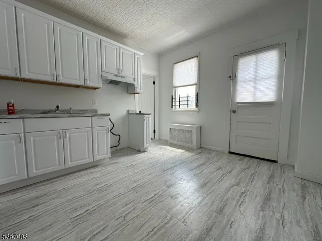 a kitchen with cabinets and wooden floor