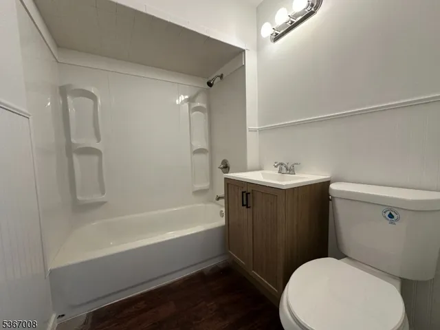 a bathroom with a sink a toilet a mirror and bathtub