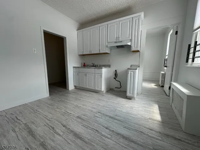 a kitchen with a sink a refrigerator and cabinets