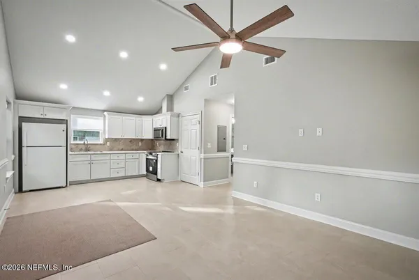 a view of a kitchen with a sink and white cabinets