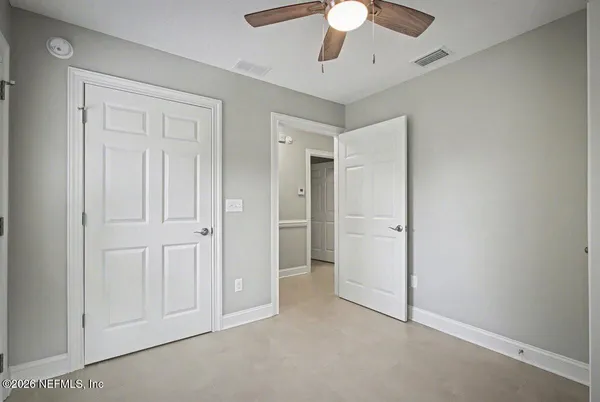 an empty space with closet and a ceiling fan