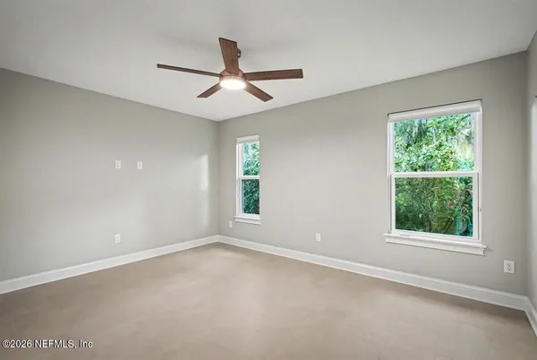 an empty room with a window and a fan