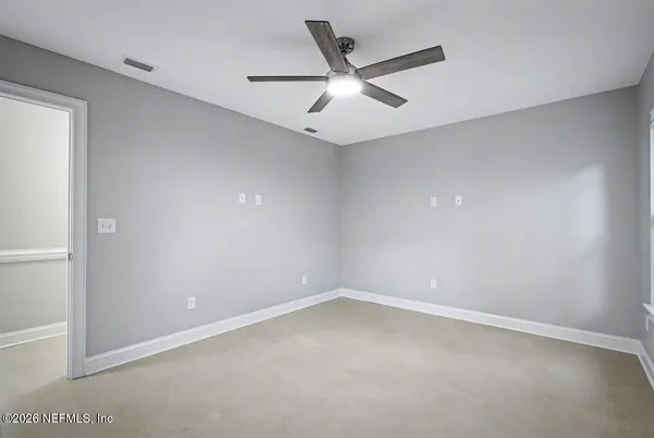 an empty room with a ceiling fan and window