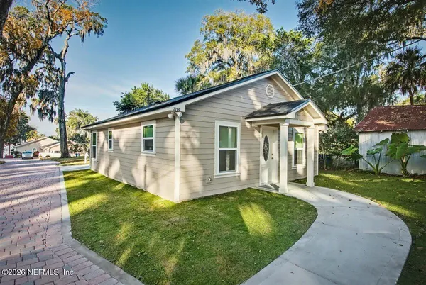 a front view of a house with a yard and trees