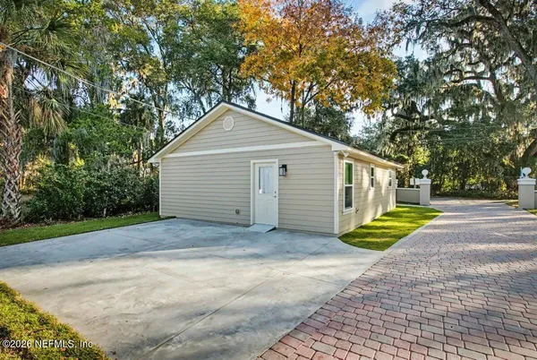 a view of a house with a yard and large tree
