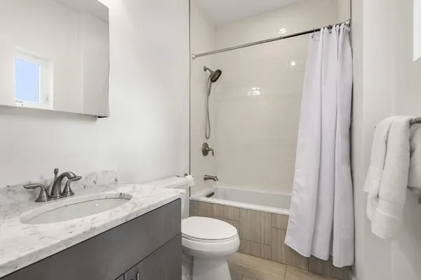 a bathroom with a granite countertop sink toilet and shower