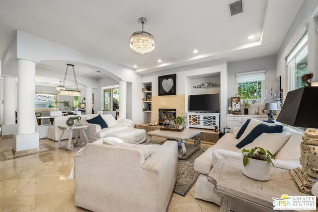 a living room with furniture a fireplace and a flat screen tv