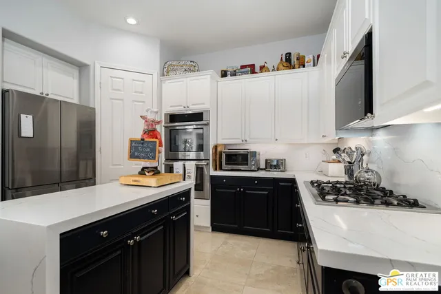 a kitchen with stainless steel appliances a sink a stove and refrigerator