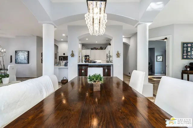 a view of a dining room with furniture a chandelier and wooden floor