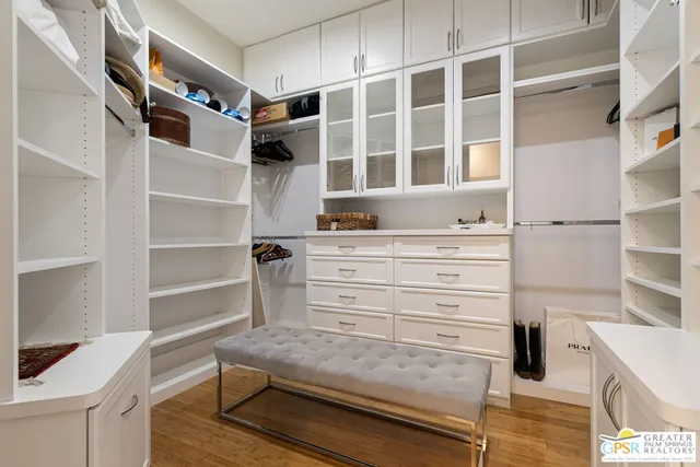 a view of walk in closet with clothes and shoes
