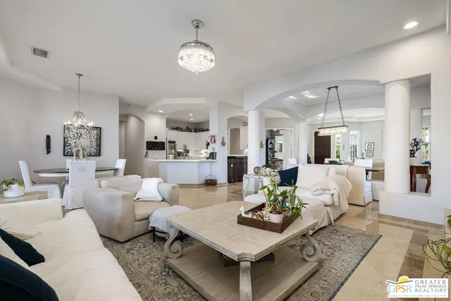 a living room with furniture and a chandelier