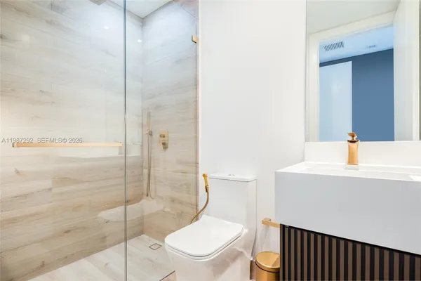 a bathroom with a toilet a sink and shower