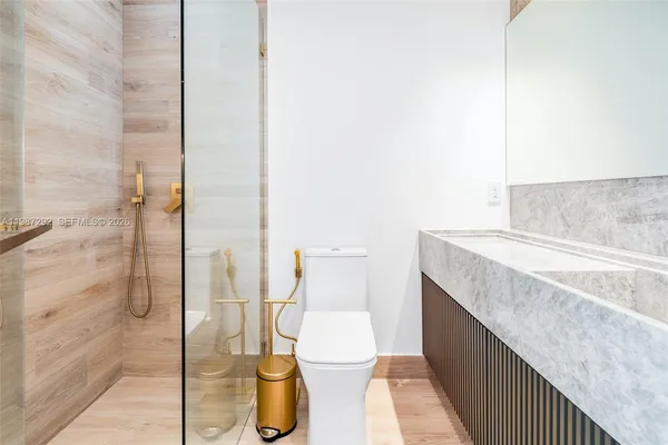 a bathroom with a granite countertop sink and a toilet