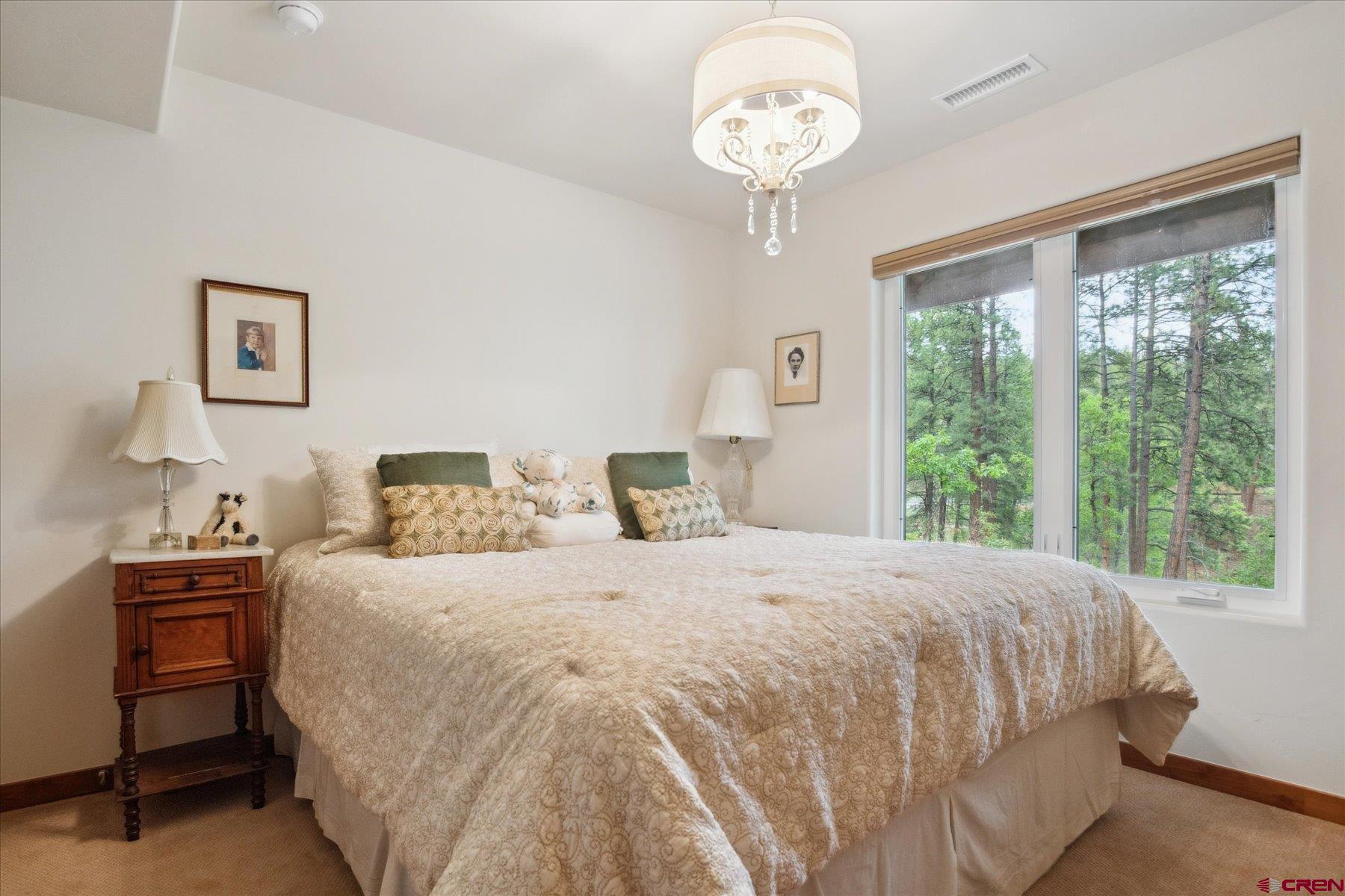 152 Red Canyon Trail, Unit R Durango, CO 81301 - Photo 31 of 42 a bedroom with a large bed and a chandelier
