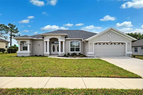 a front view of a house with a garden and yard