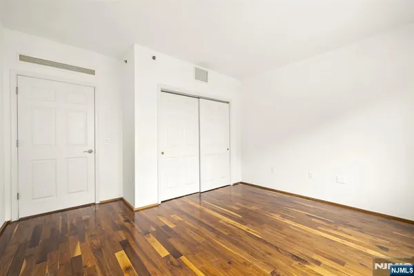 a view of empty room with wooden floor