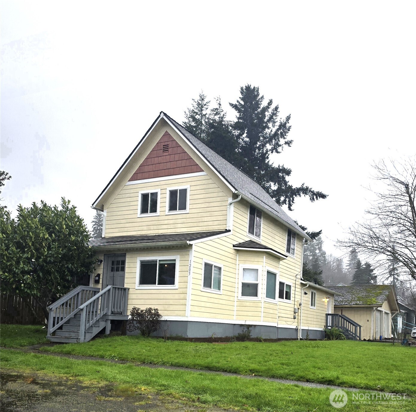 1205 Cedar Street Raymond, WA 98577 - Photo 1 of 8 a front view of a house with a garden and trees