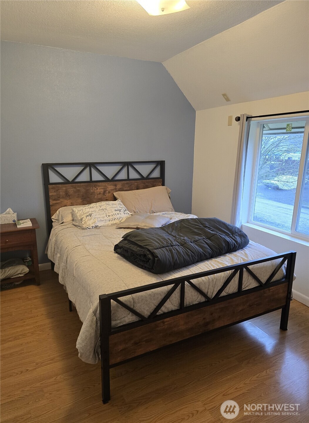 1205 Cedar Street Raymond, WA 98577 - Photo 5 of 8 a bed sitting in a bedroom next to a window