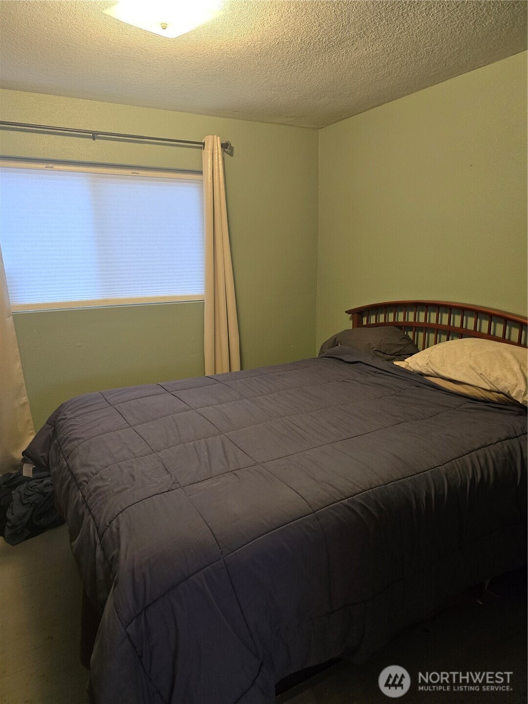 1205 Cedar Street Raymond, WA 98577 - Photo 7 of 8 a bed sitting in a bedroom next to a window