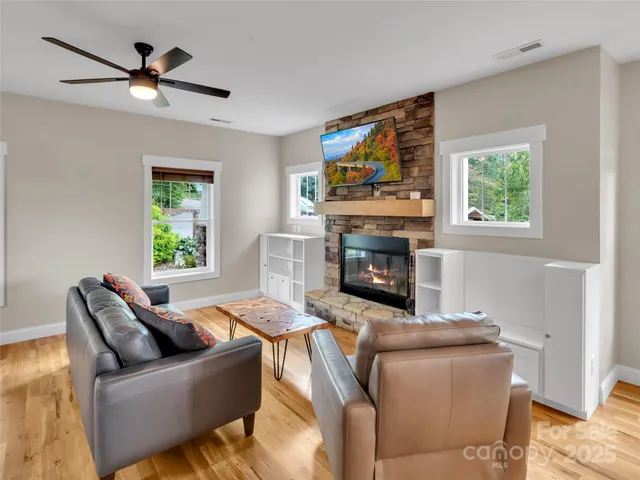 a living room with furniture a fireplace and a flat screen tv