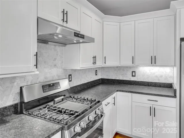 a kitchen with stainless steel appliances granite countertop a sink stove and cabinets