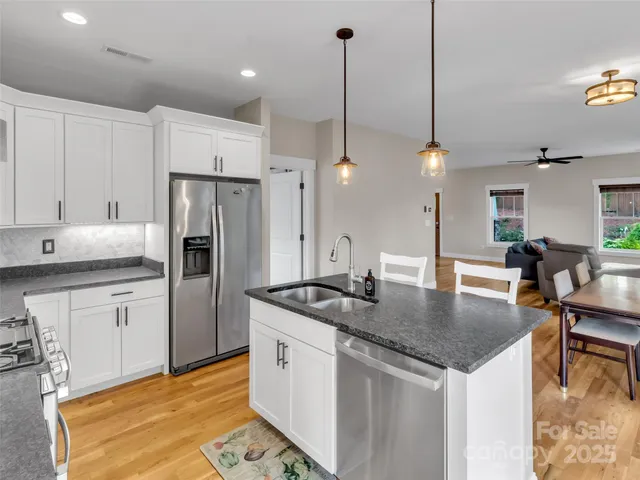 a kitchen with kitchen island a counter top space appliances and cabinets