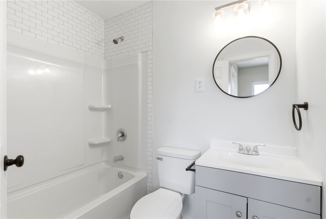 40 Woods Road Springboro, OH 45066 - Photo 38 of 57 This bright bathroom features subway tile, a combined shower and tub, and a vanity with a sink.