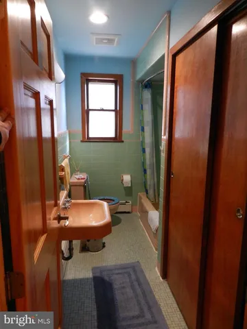 a bathroom with a toilet a sink and a mirror