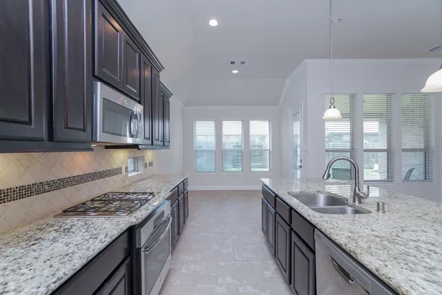 a kitchen with granite countertop a sink and a stove