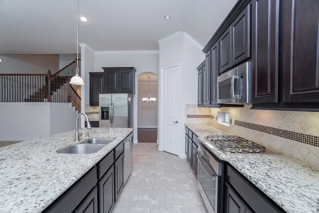 a kitchen with stainless steel appliances granite countertop a sink stove and cabinets