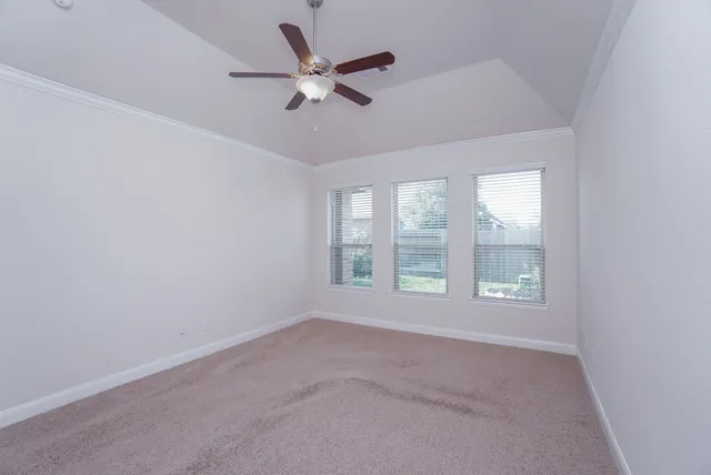 an empty room with a window and a fan