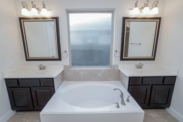 a bathroom with a bathtub a sink and a mirror