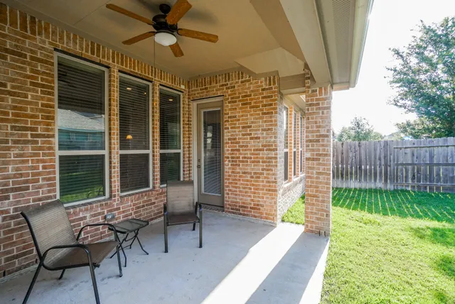 a view of a porch with chairs and a yard